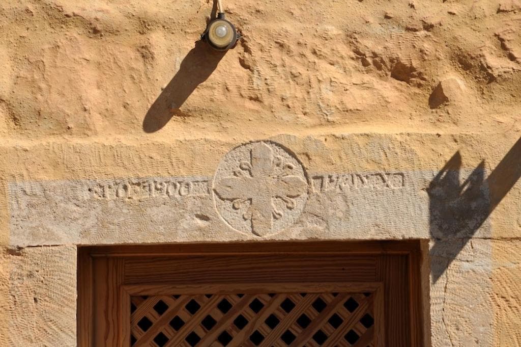 Historic stone carving and cross above the original doorway of Villa Alexandrou