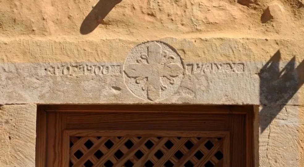 Historic stone carving and cross above the original doorway of Villa Alexandrou